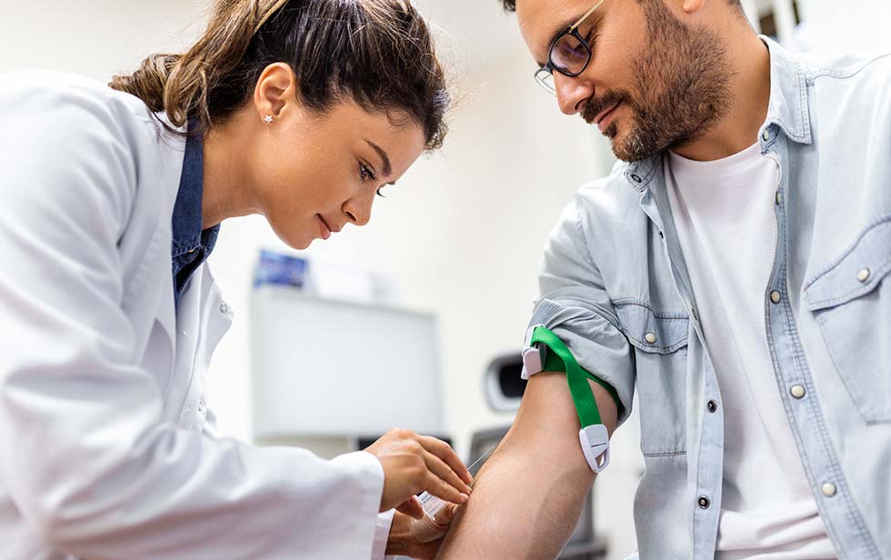 um médico a tirar sangue de um paciente